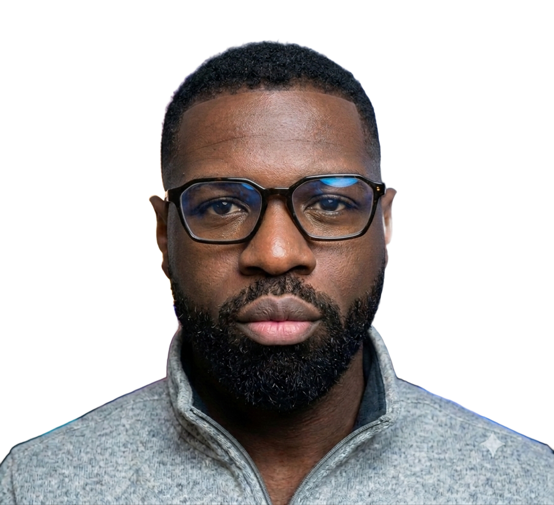 Francis Darko, photographed from the chest up, wearing glasses and a grey quarter-zip.